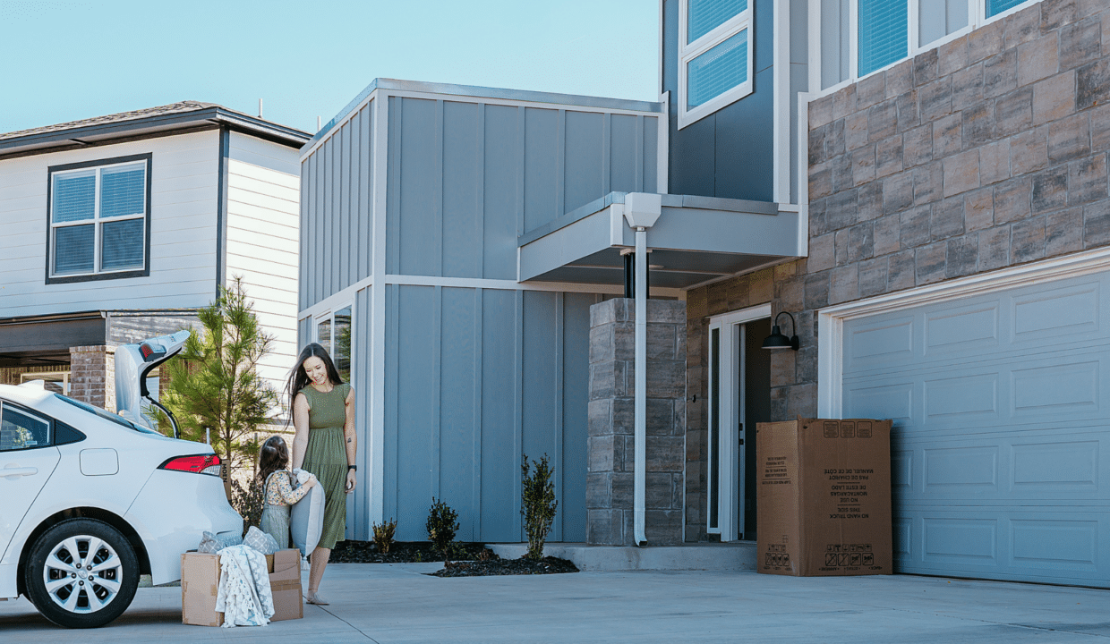 A woman moving boxes from a car to her energy-efficient home with her daughter